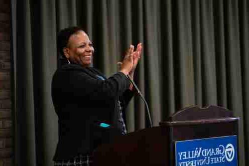 Woman claps at a podium