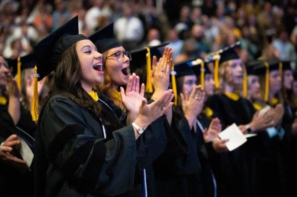 毕业典礼上，身着硕士袍的毕业生鼓掌欢呼.