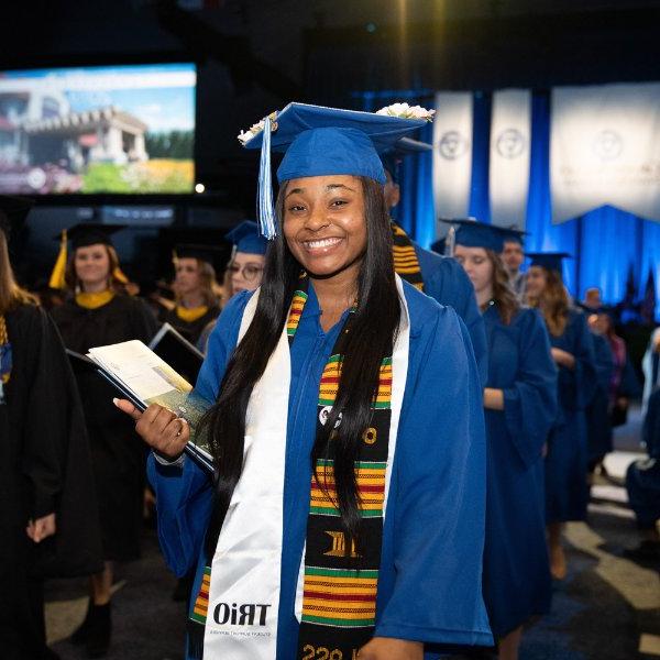 一名2019年的毕业生在毕业典礼上穿着三人组披肩、帽子和礼服