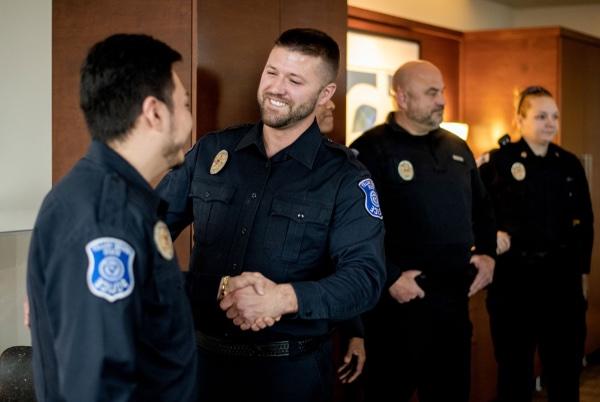 汤姆·伯恩斯和马尔科·罗哈斯-加西亚在宣誓就任大峡谷警察局警官后握手.