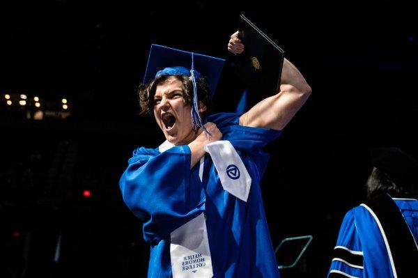  一名大学生拿到毕业证书后在舞台上秀肌肉. 