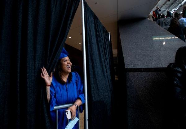  毕业典礼上，一名大学生从窗帘后面偷看家人. 
