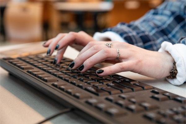 A closeup of a person typing on a keyboard.