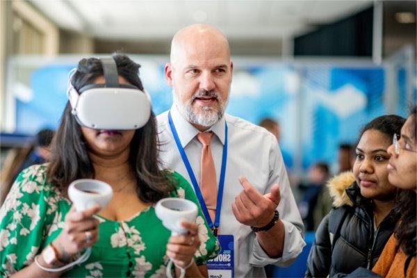 斯科特Truskowski, center, 介绍了在2024年Reach Higher展示期间使用VR模块来增强学生对实验室技能的学习.
