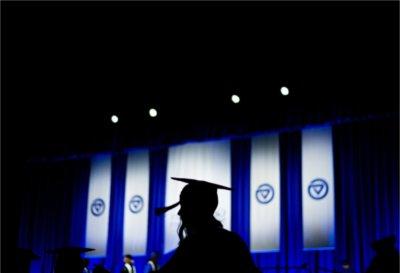 毕业典礼上，一个毕业生的剪影走在舞台前.