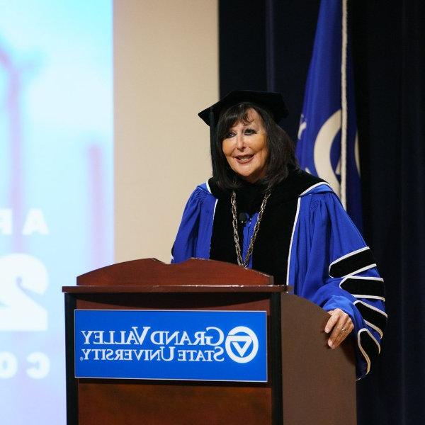 President Philomena Mantella behind podium in regalia