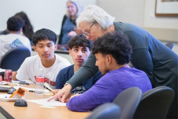 Marianne Essing, from Mercantile Bank, assists TRIO Upward Bound Grand Rapids seniors during a Money Masters program at the L. William Seidman Center. 