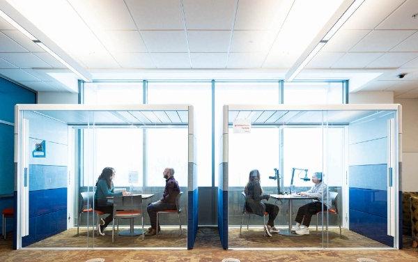 A photo of a podcasting booth and a study booth at the Digital Creator Lab, with two students in each. 