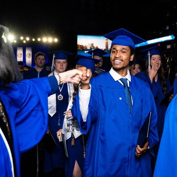 President Mantella fist bumps with a graduate