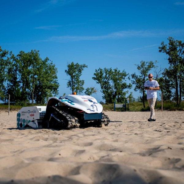 一架无人机在海滩上清理塑料和垃圾.
