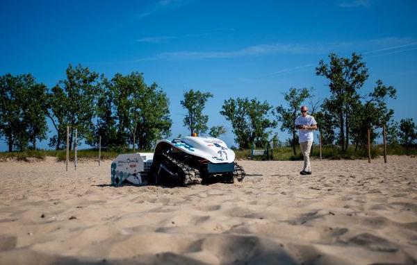 一架无人机在海滩上清理塑料和垃圾.